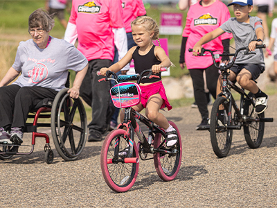 Girl riding bike during Running of the Pink